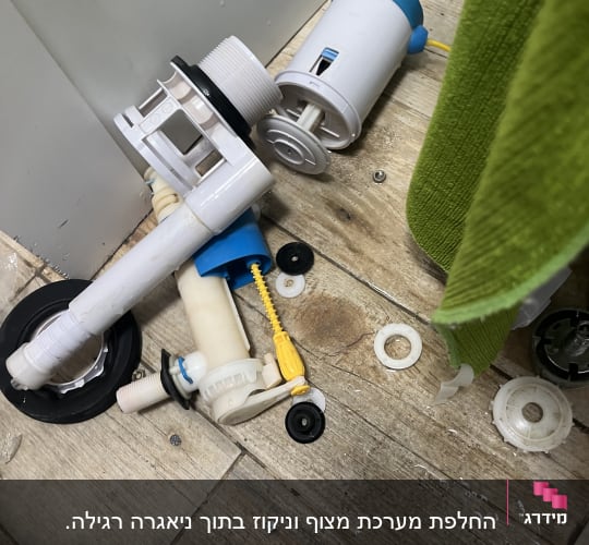 חלקי אסלה מפורקים על רצפה עם מפתח ברגים